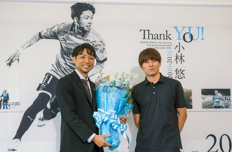 小林悠の引退会見。現キャプテンの脇坂泰斗から花束を贈呈され笑顔を浮かべる　©JIJI PRESS
