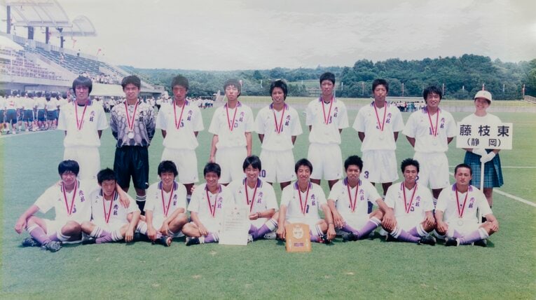 2001年インターハイ準優勝時の記念写真。後段左端が長谷部、右に一人挟んで小林監督（当時高2）。成岡翔や大井健太郎、岡田隆の姿も（学校提供）