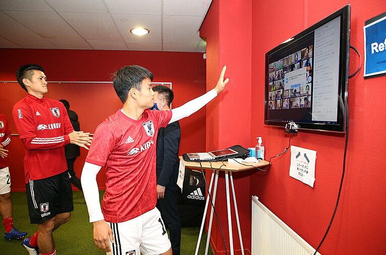 試合前、日本のファンとリモートハイタッチをする久保建英。欧州遠征では様々な工夫と試行錯誤がなされていた ／ photograph by JFA/AFLO