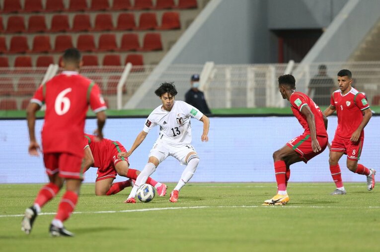 オマーンの選手に囲まれながらボールを受ける三笘薫。川崎フロンターレでともにプレーした中村憲剛氏は「立ち位置の絶妙さ」を指摘する ／ photograph by AFLO