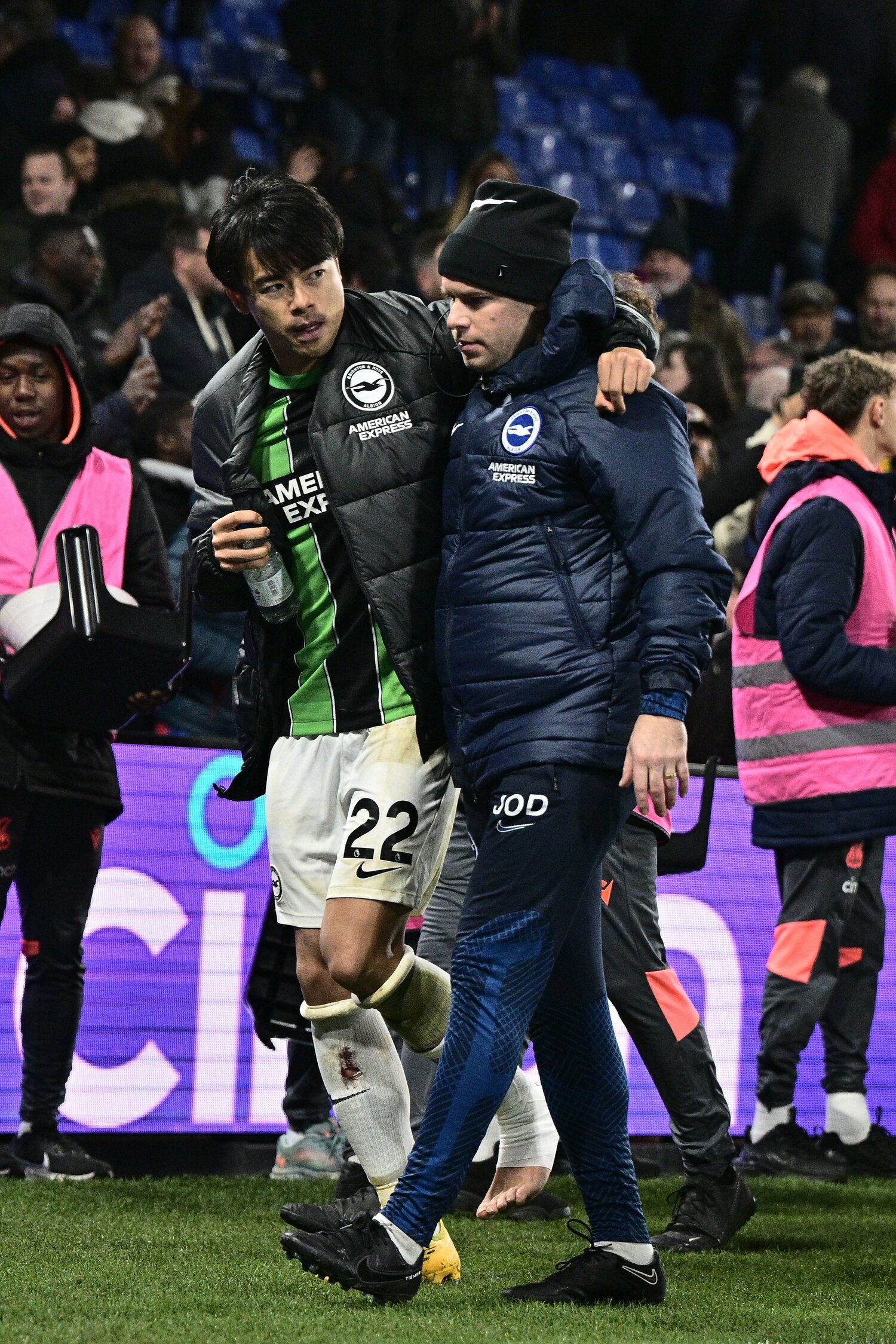 12月21日のクリスタルパレス戦、左足首を痛めた三笘薫。クラブスタッフの肩を借りて、ケンケンで控え室へ戻る　©Getty Images