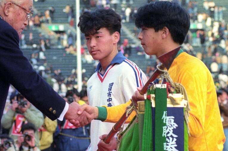 1992年1月の高校サッカー選手権。四日市中央工高と同時優勝し、優勝旗を受ける帝京高キャプテン・日比威 ／ photograph by KYODO