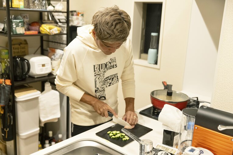 台所に立つ大久保　©Katsuyuki Masuda（SIGNO）