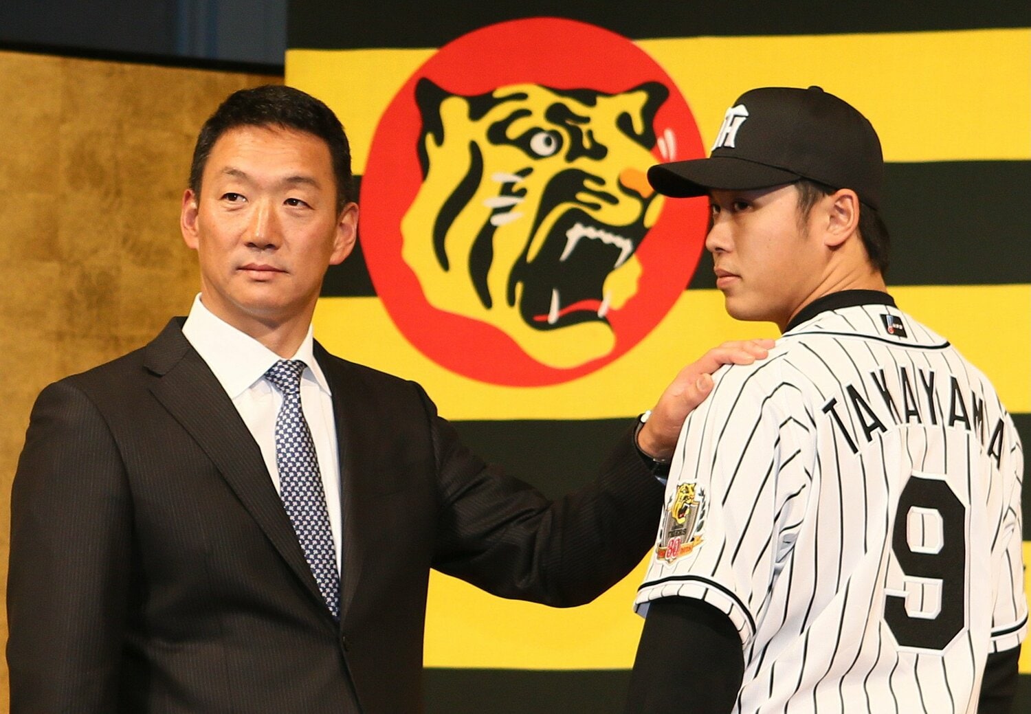 ヤクルトとの2球団競合の末、2015年のドラフト1位で明治大から阪神へ入団。左は当時の金本知憲監督　©JIJI PRESS