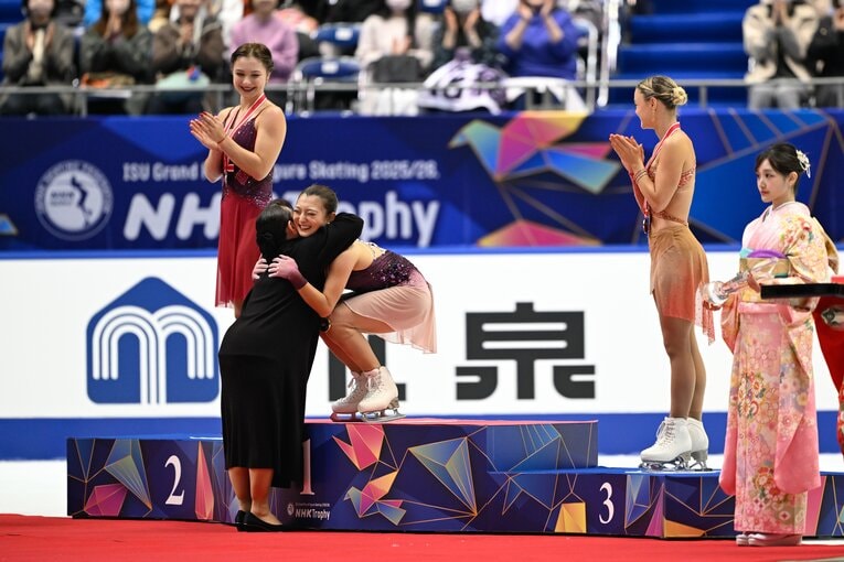 NHK杯でプレゼンターの伊藤みどりから金メダルをかけられた後、笑顔でハグをする坂本花織　©️Asami Enomoto