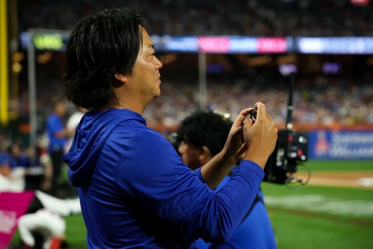 ホームランダービーの様子をカメラに収める八木通訳。6歳下の村上を「ムネさん」と呼ぶ　©︎Chris Graythen/Getty Images