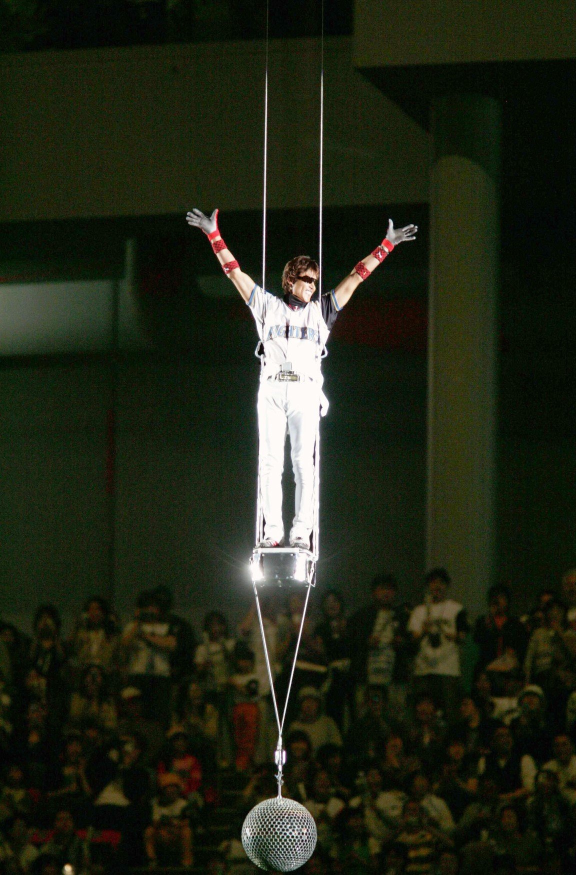 札幌ドームの天井からミラーボール付きの小型ゴンドラに乗って登場した新庄　©KYODO　