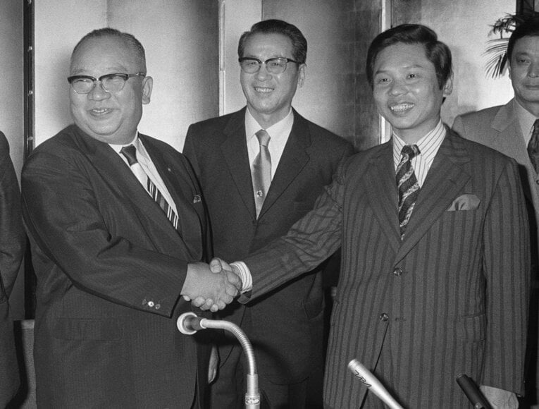 球団譲渡式の後、握手する大社義規日本ハム社長（左）と西村昭孝日拓社長。中央は三原脩新球団社長　©JIJI PRESS