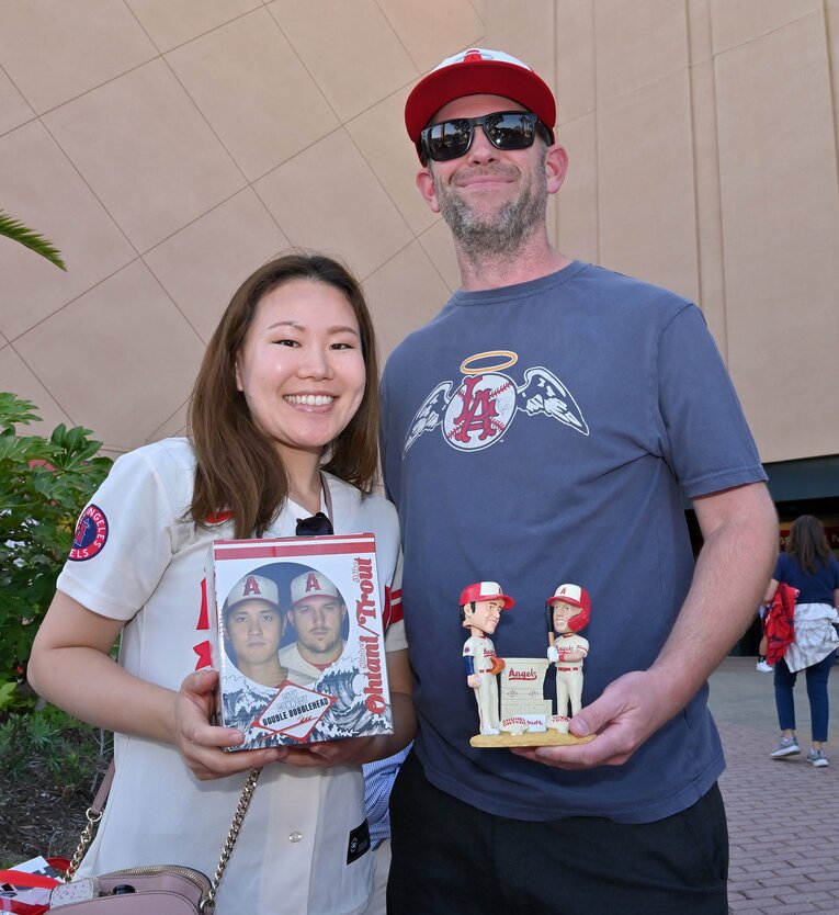 来場者記念の“トラウタニ”グッズを手に嬉しそうなファン　©JIJI PRESS