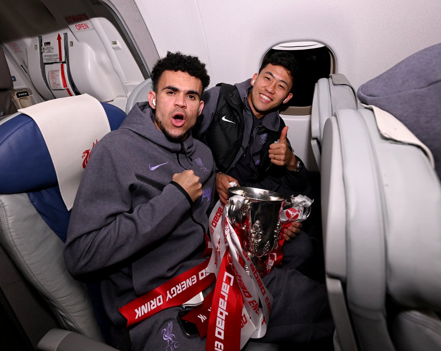 リーグカップ優勝の後、帰りの飛行機で。遠藤の隣はFWルイス・ディアス　©Getty Images