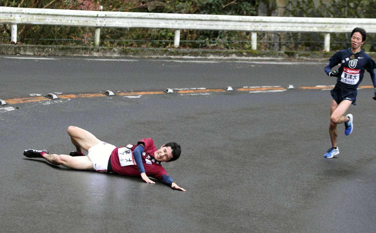 滑って転倒する早大の早稲田大6区・高野寛基　©︎JIJI PRESS