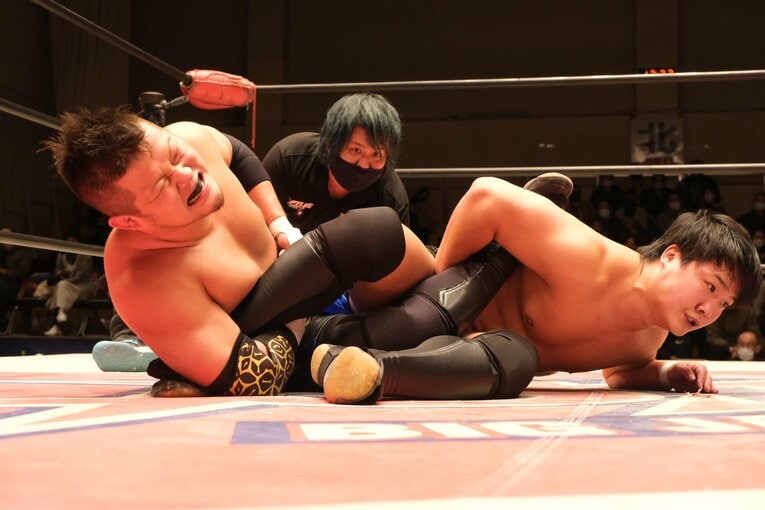 野村のアキレス腱固めに苦悶の表情を浮かべる