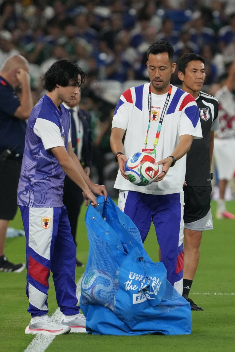 試合前練習で使用したボールを回収する吉田麻也と南野拓実　©Masashi Hara