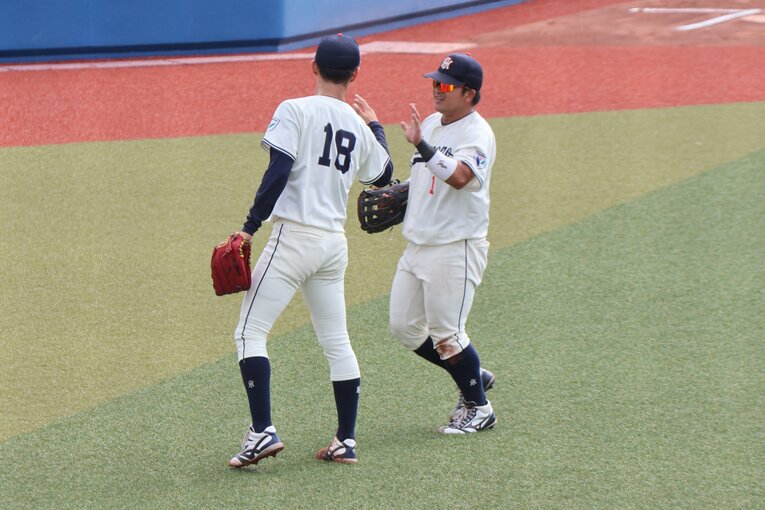 公式戦でチームメイトとハイタッチを交わす花園大の藤原聡大　©Fumi Sawai