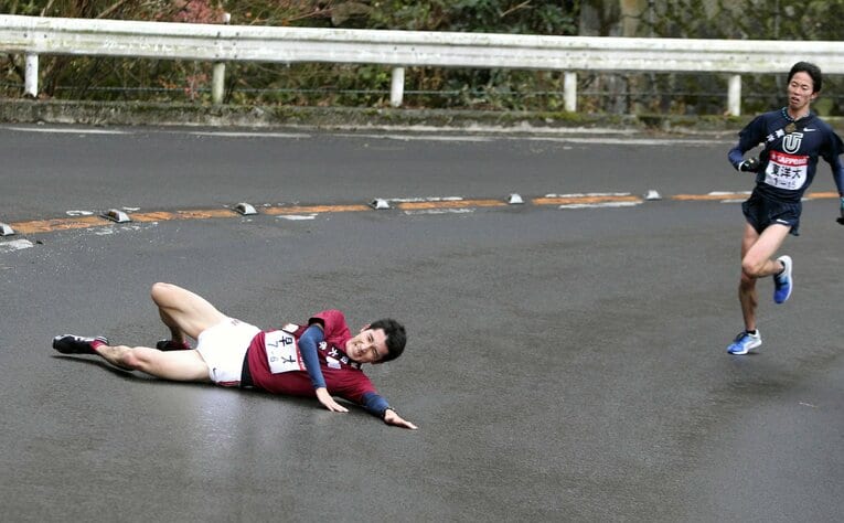 滑って転倒する早大の早稲田大6区・高野寛基　©︎JIJI PRESS