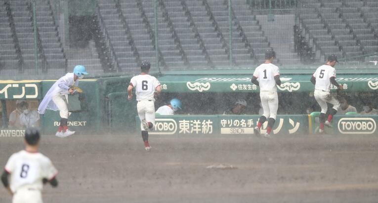 大粒になった雨に、ベンチへと戻る日大東北の選手たち　©Kyodo News