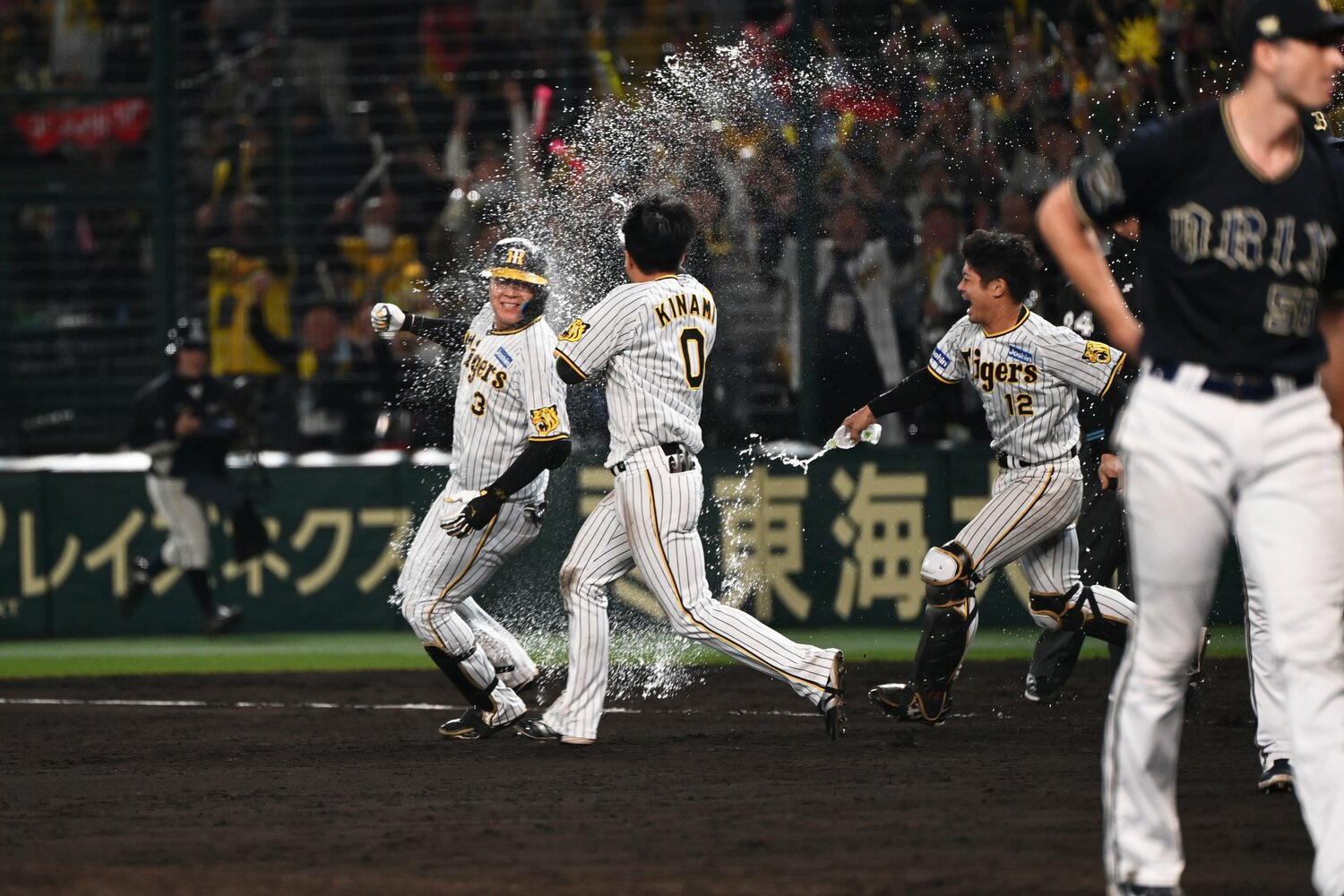 大山のもとに駆け寄りペットボトル水で祝福する木浪聖也と坂本誠志郎　©︎Naoya Sanuki