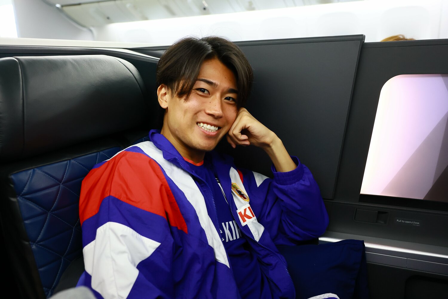 中村敬斗、日本からモンテレイの事前合宿への機内で。写真は個室感のあるビジネスクラスだが、W杯期間中の移動はエコノミークラスのシートだった　©JFA／AFLO