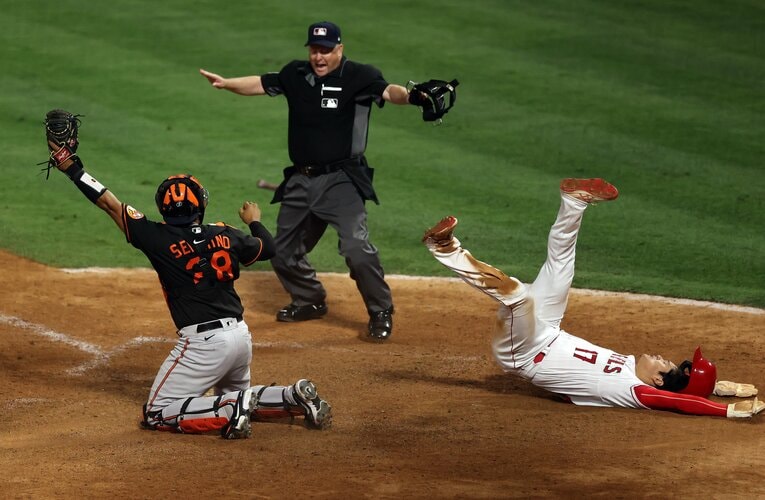 本塁生還で倒れ込みながら審判と一緒にセーフ©Getty Images