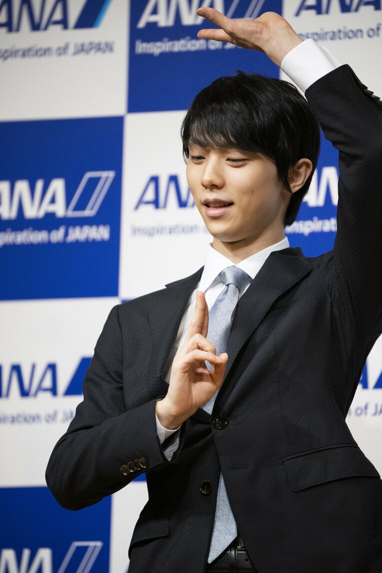 記者からの要望に応えポーズを取る羽生。会場が笑顔に包まれた瞬間だった