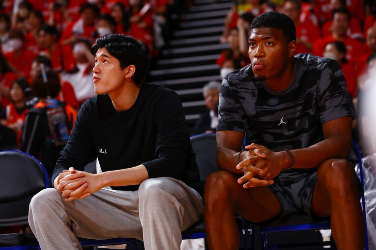 7月の韓国戦、ベンチから戦況を見つめる渡邊雄太と八村塁　©︎Kenzaburo Matsuoka/AFLO)