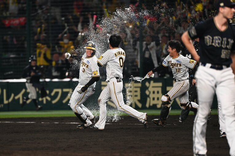 大山のもとに駆け寄りペットボトル水で祝福する木浪聖也と坂本誠志郎　©︎Naoya Sanuki