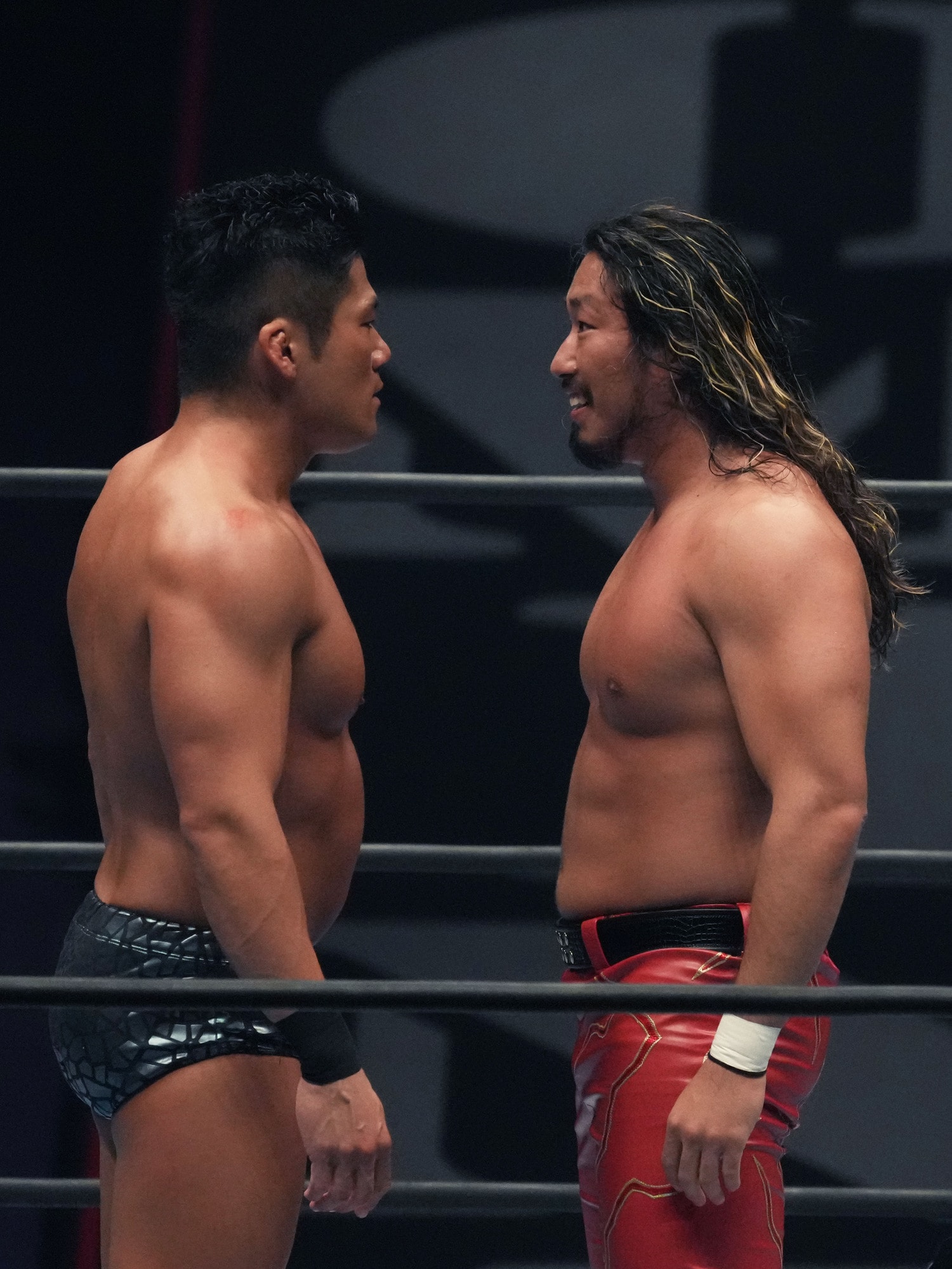 IWGP王者のSANADAを前にしてニヤリと笑う辻陽太