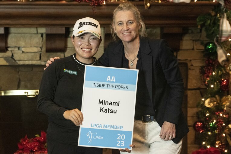 「LPGA MEMBER」と記載されたボードを手に笑顔の勝みなみ。コミッショナーのモリー・マルコーと記念撮影　©︎Getty Images
