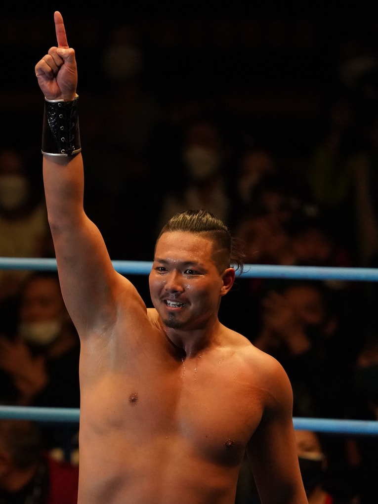 人差し指を天に突き上げるジェイク・リー