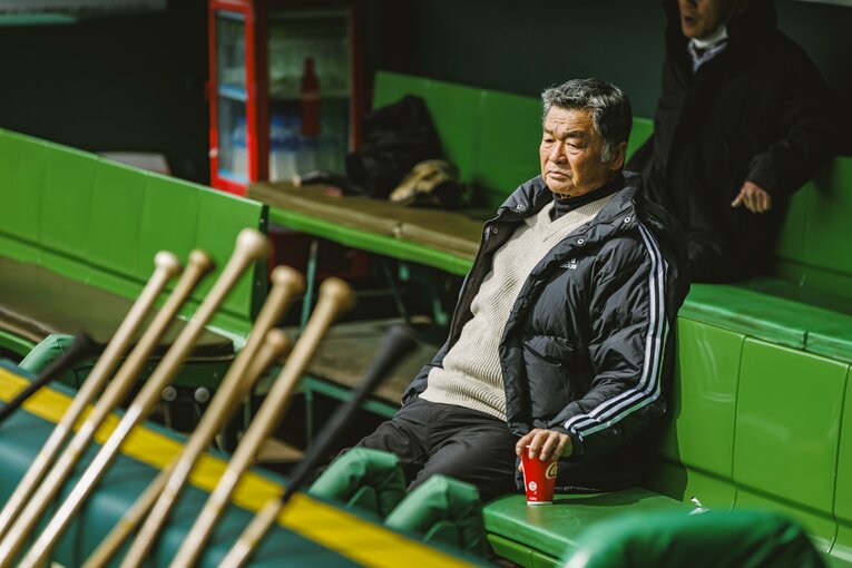 ベンチから試合前練習を見守る川藤氏　©︎Kiichi Matsumoto