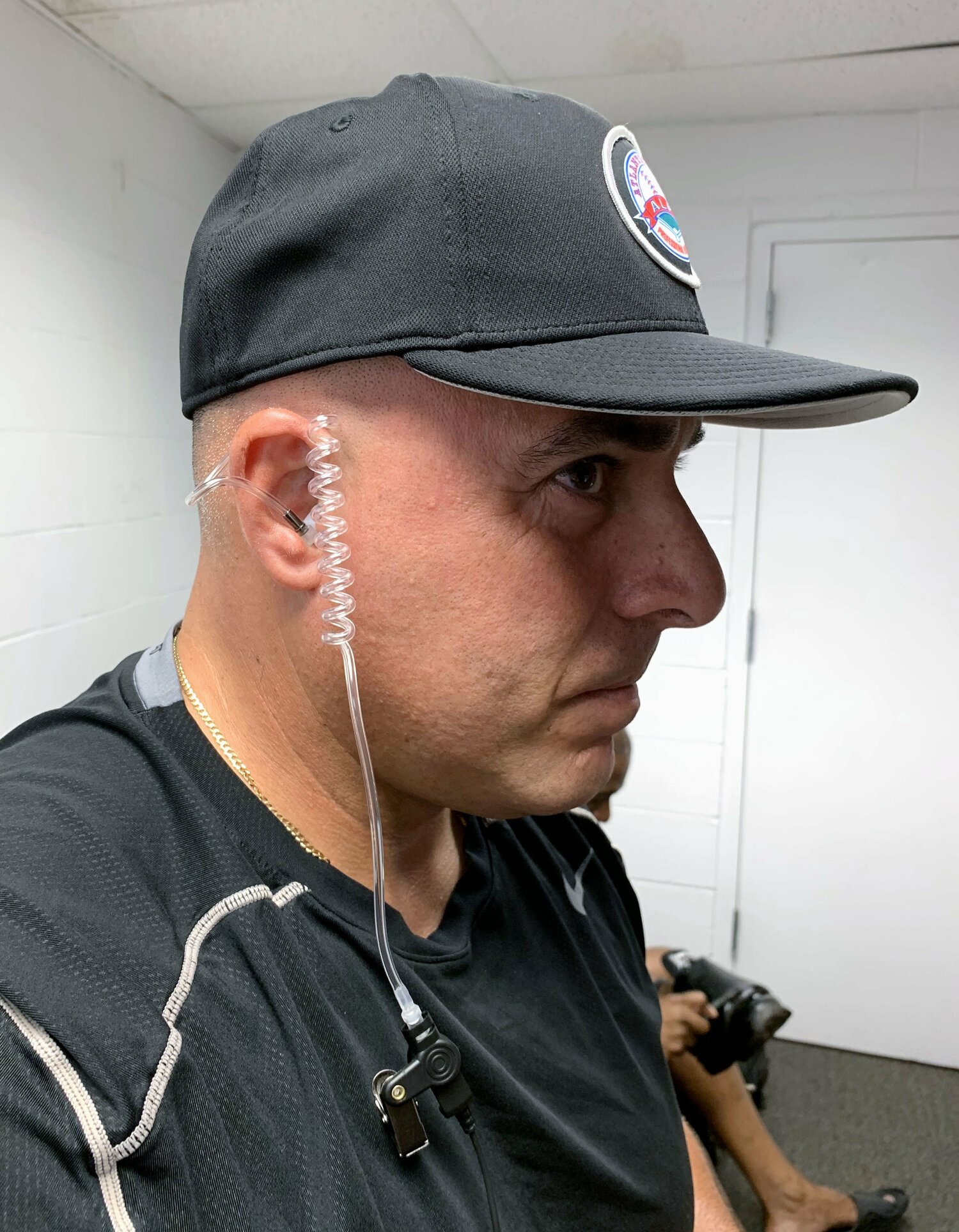 コンピューターの判定を受信するためのイヤホンを着けるマイナーリーグの審判員（撮影は2019年）©KYODO