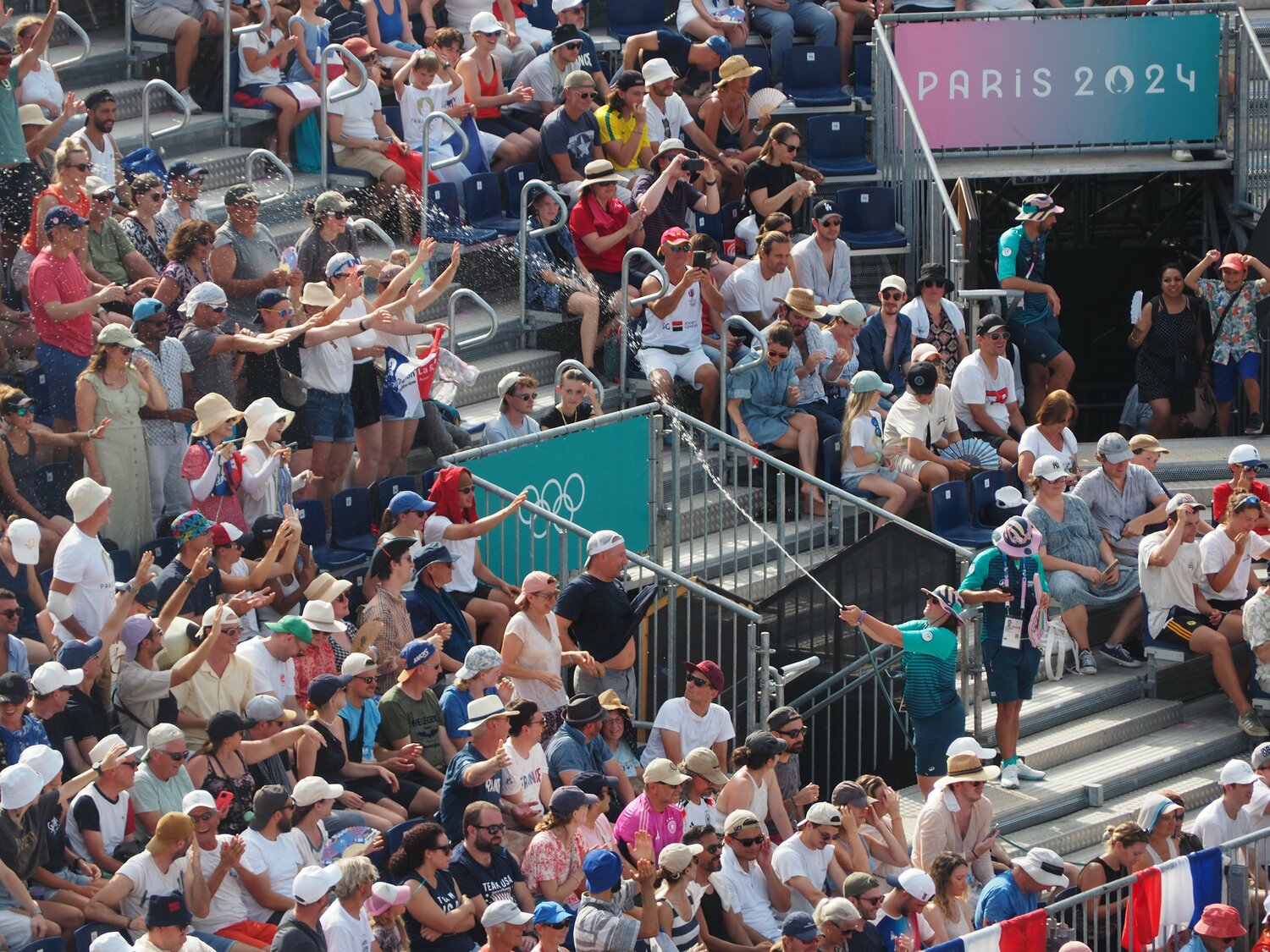 客席にホースで散水するボランティアスタッフ ©JMPA