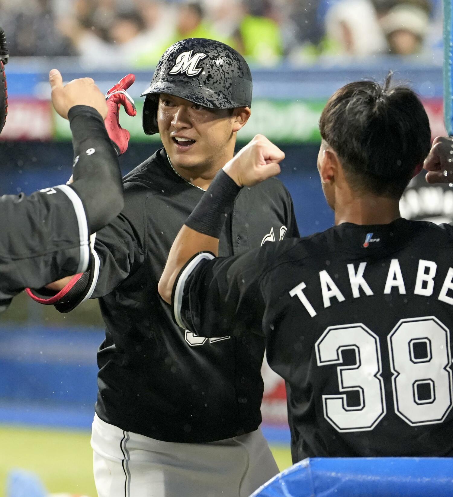 雨の神宮球場でホームランを放ちベンチで祝福を受ける佐藤都 ©︎KYODO