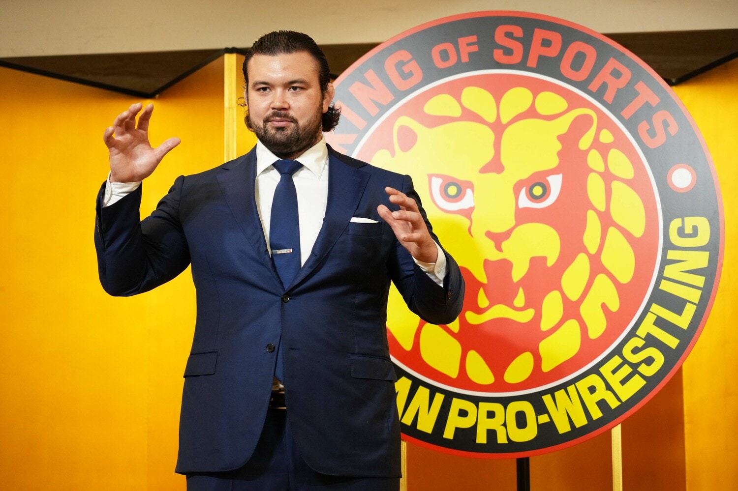 ライオンマークの前でポーズをとるウルフアロン　©Essei Hara