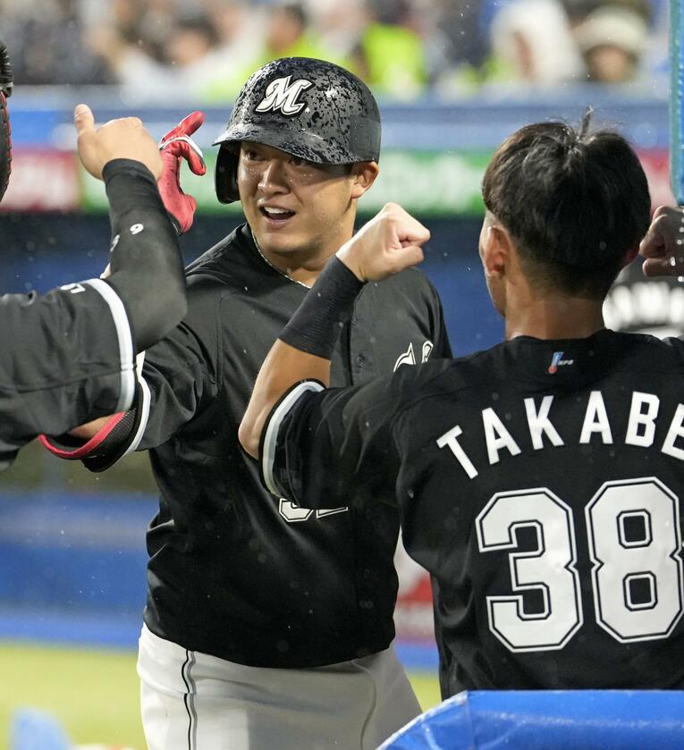 雨の神宮球場でホームランを放ちベンチで祝福を受ける佐藤都　©︎KYODO