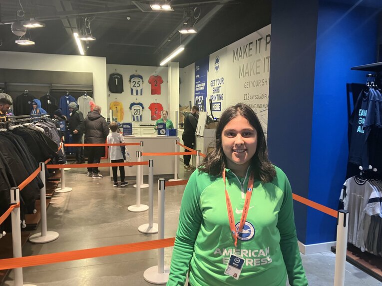 取材に応じたスタジアム併設ショップ店員のジェイミー・ハリアさん「（売り切れになるまで）三笘のユニフォームが断トツで売れていました」