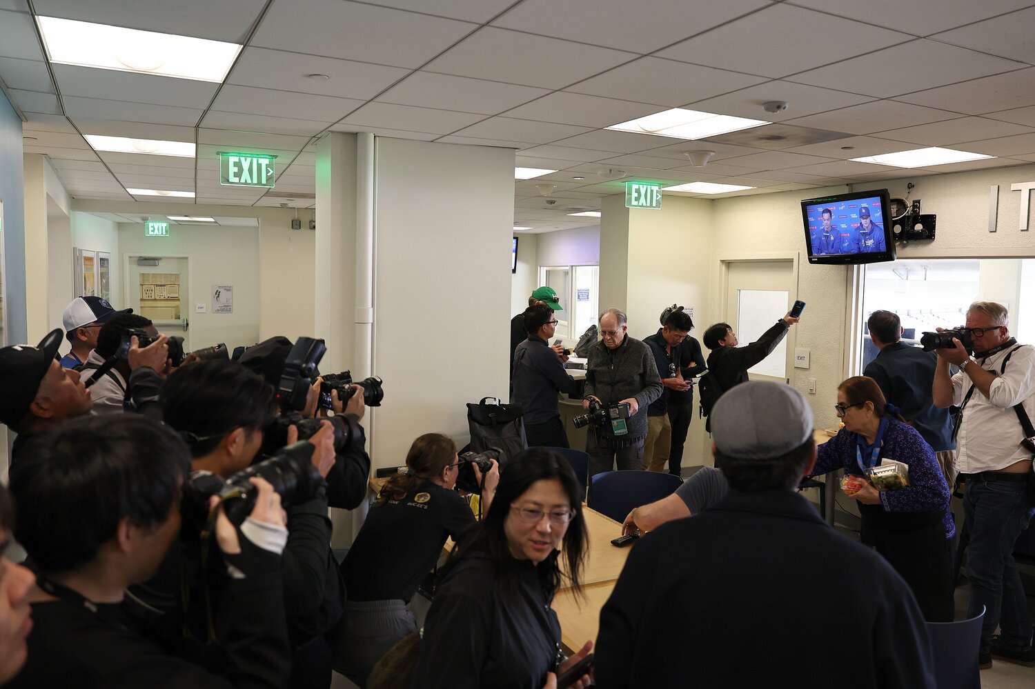現地3月25日の大谷翔平の会見。カメラマンは入室できず、テレビ画面を撮影する姿も　©Getty Images