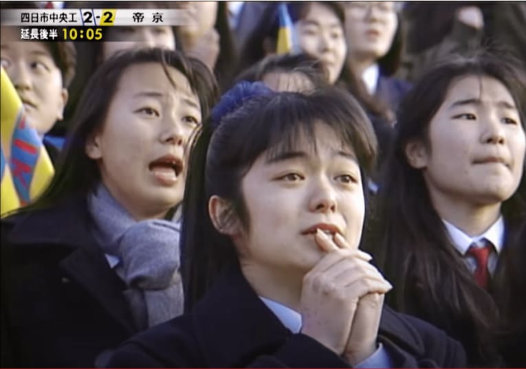 第70回高校サッカー選手権決勝・帝京vs四日市中央工業の試合をスタンドで観戦する当時高校1年生の東尾理子（後方左）　※高校サッカー公式YouTubeより