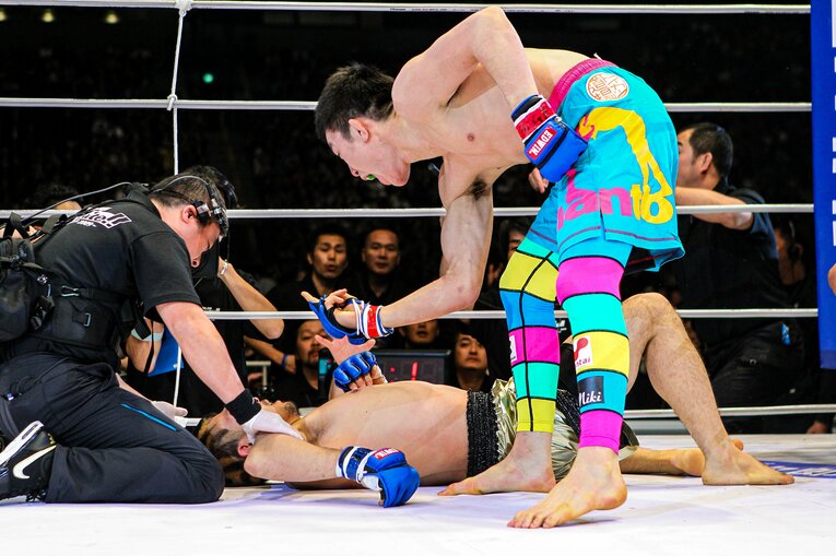 横たわる廣田瑞人に中指を突き立てる青木真也　©Susumu Nagao