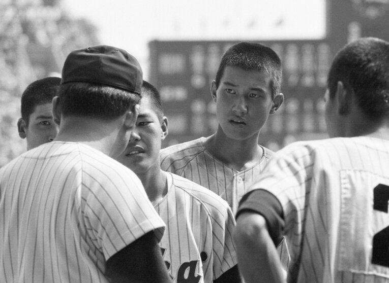 筆者のもっとも古い夏の甲子園の記憶。1974年大会、東海大相模の原辰徳（当時1年）。父親の原貢監督（手前）の話を真剣な表情で聞く　©KYODO