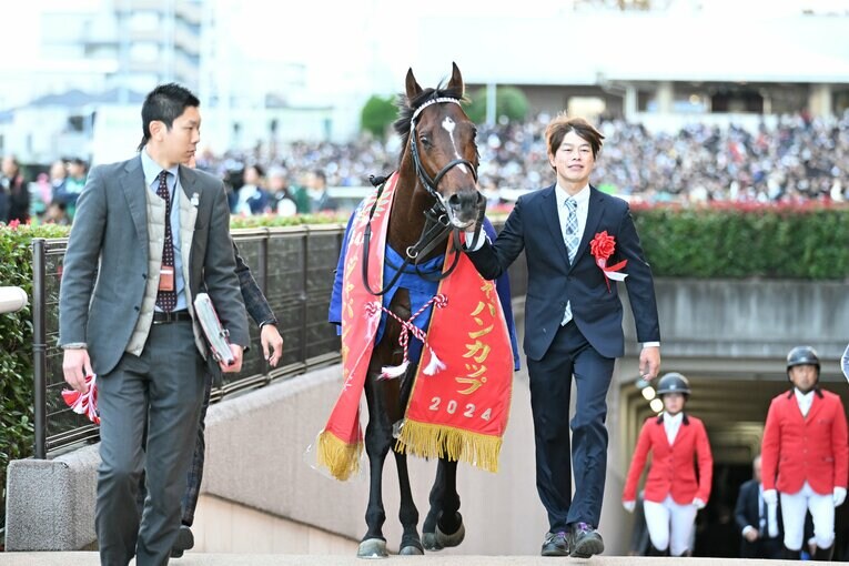 優勝レイをかけられ、地下馬道から姿を現したドウデュース　©Keiji Ishikawa