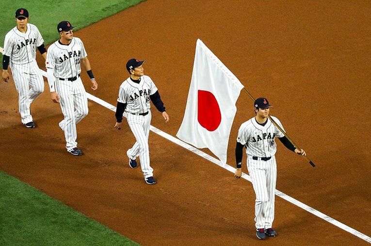 アメリカ戦前、日の丸の旗手も務めた大谷翔平。星条旗を持ったトラウトとともに、映画ばりの構図だった ／ photograph by UPI/AFLO