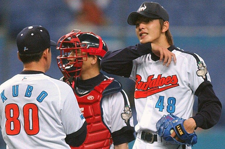 マウンドにいる岩隈のもとへ駆け寄り言葉をかける久保コーチ（当時） ／ photograph by Kyodo News