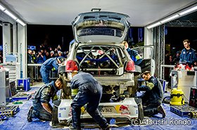 サービスパークでメンテナンスするフォルクスワーゲンのメカニック。テントの外では大勢のファンが食い入るように作業を見つめていた。 