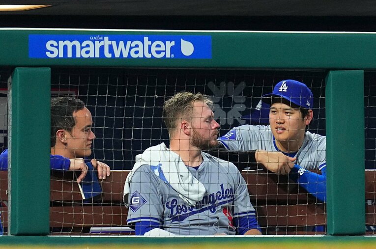 ベンチ内で会話する大谷とラックス、アイアトン氏　©Getty Images
