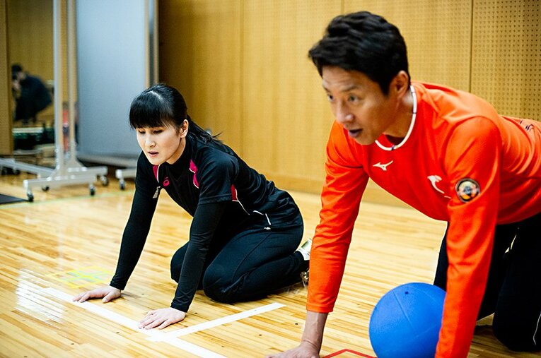 ラインテープの前で、ポジションをとる2人。テープの下には糸が通してあり、手で触ってもラインがわかりやすいようにしてある。 ／ photograph by Yuki Suenaga