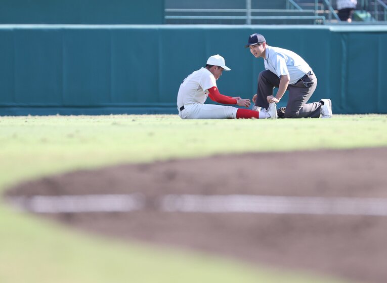 同じ試合、タイブレークの延長10回表の前。足がつったとみられる智弁和歌山のセンター藤田一波　©JIJI PRESS