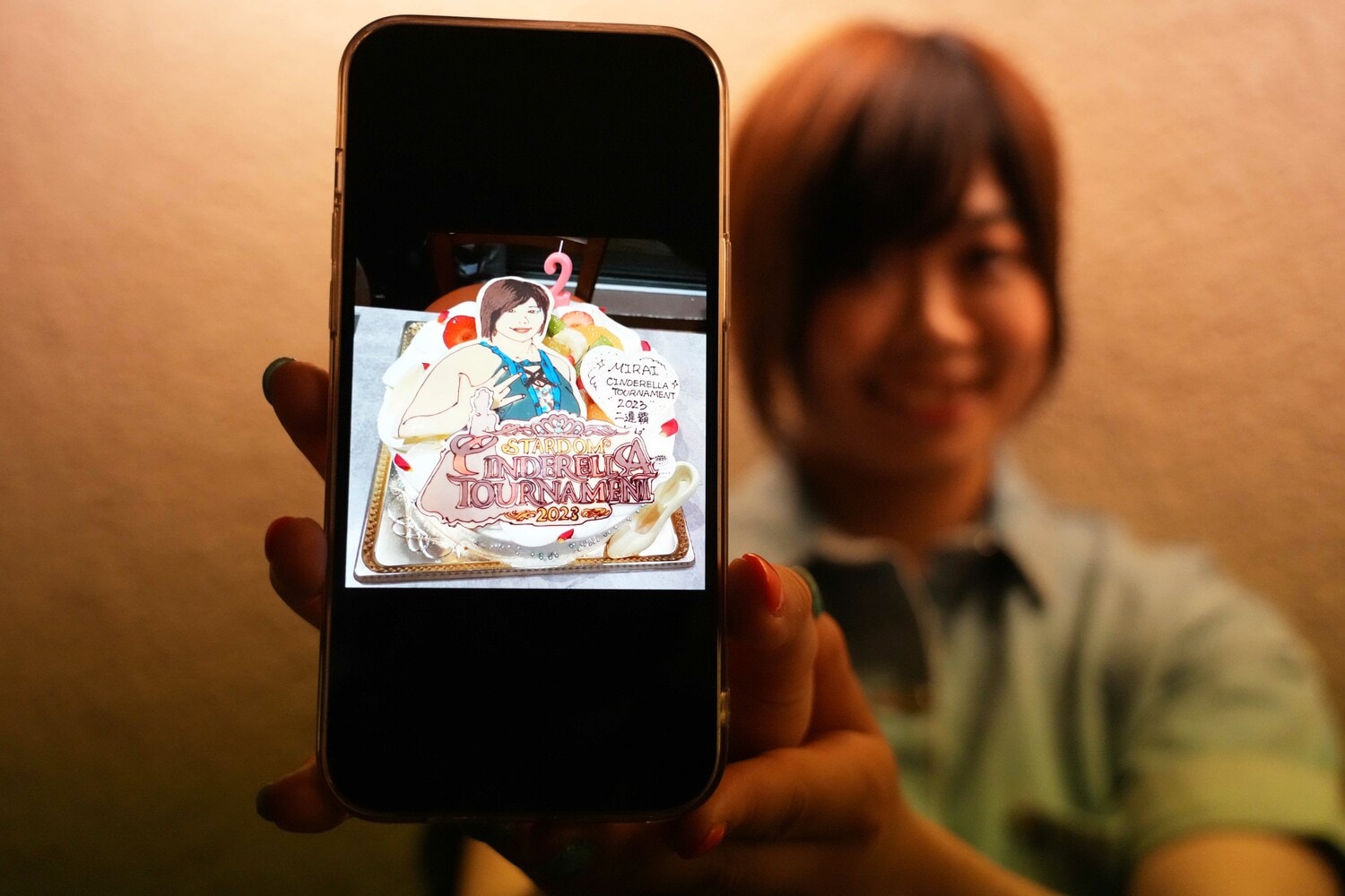 「シンデレラのケーキ」の写真を見せるMIRAI