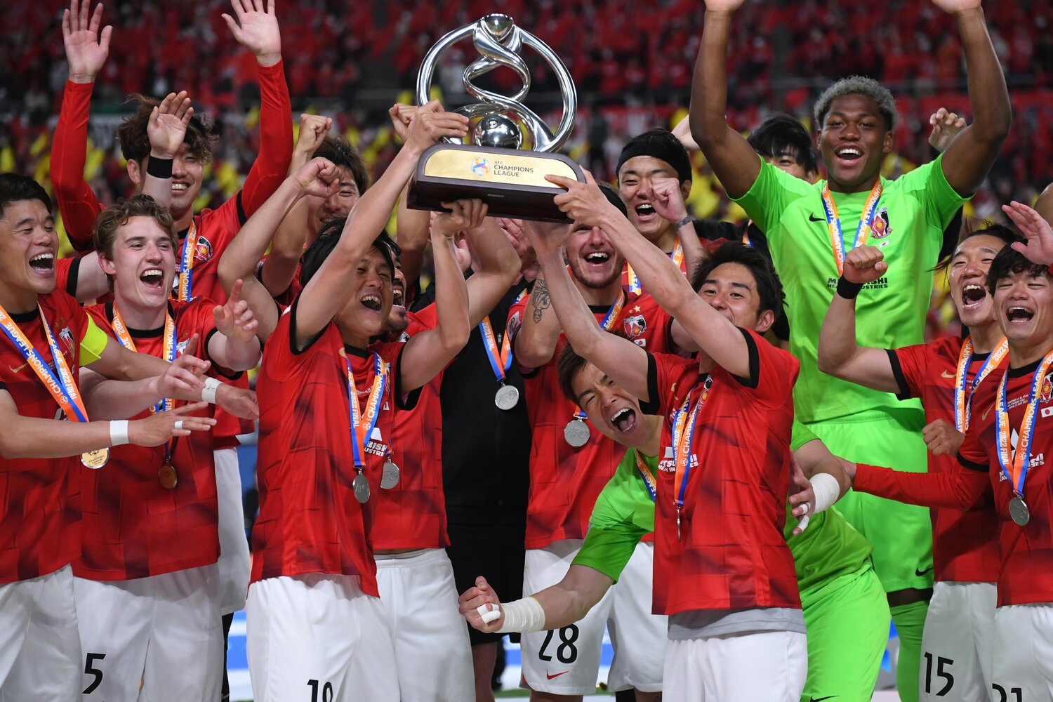 優勝トロフィーを掲げる岩尾憲と関根貴大