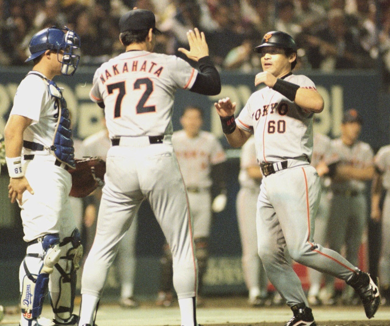 10.8決戦で先制の15号ソロを放ち、中畑清コーチに迎えられホームインする落合博満 ©KYODO